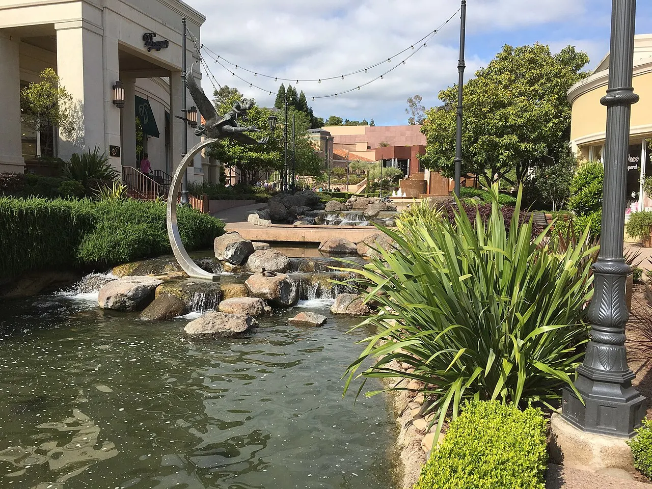 Water, landscaping and sculpture beside the shops at Blackhawk Plaza.