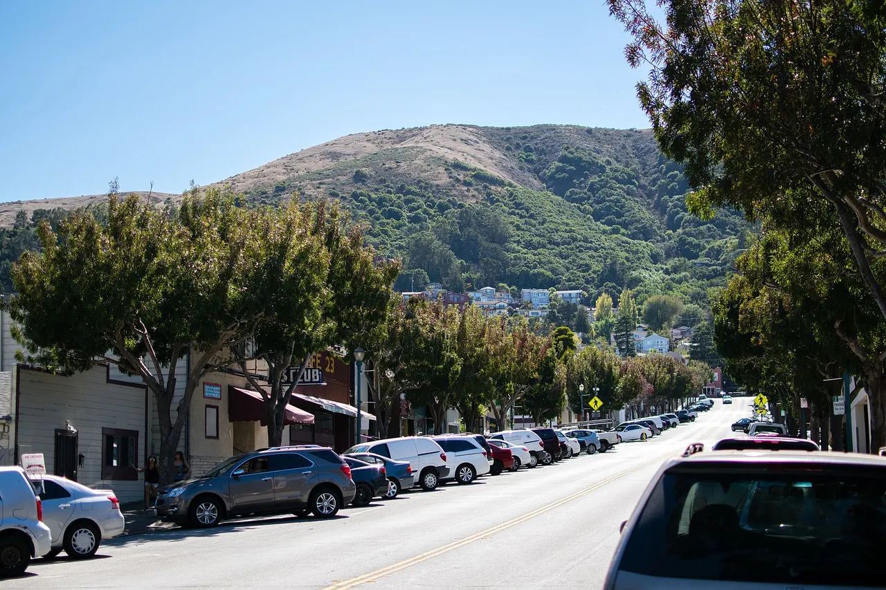 Visitacion Avenue in downtown Brisbane, with San Bruno Mountain rising behind the shops.