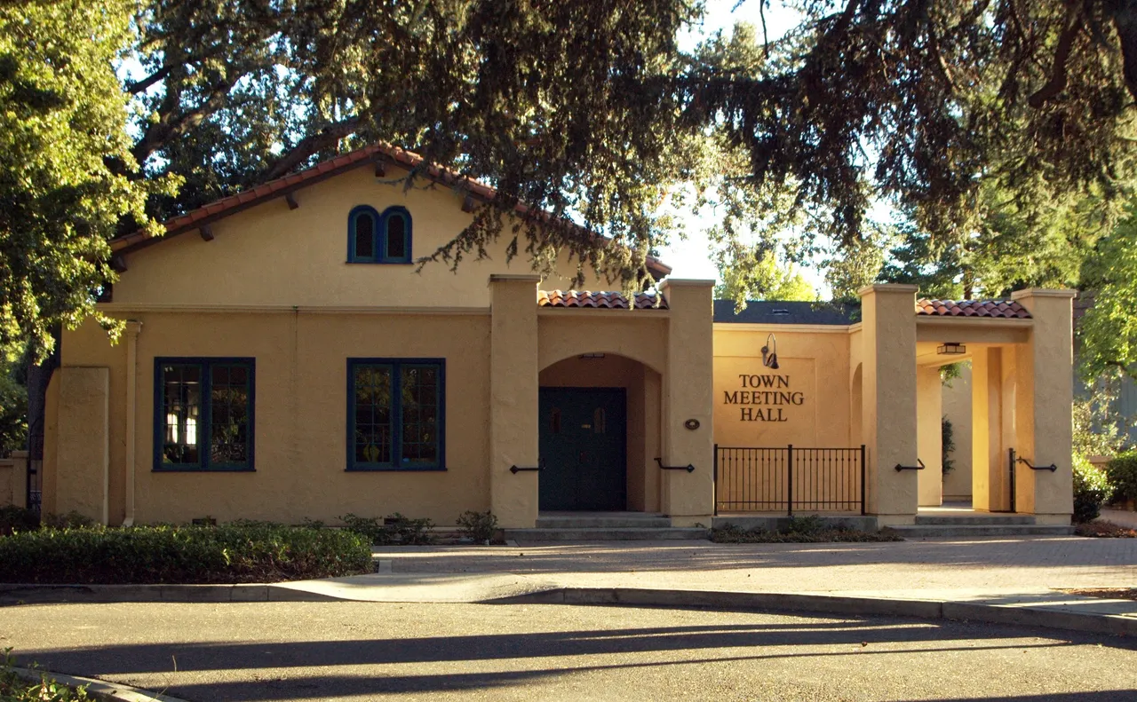 Danville Town Meeting Hall, a yellow stucco building beneath mature trees.