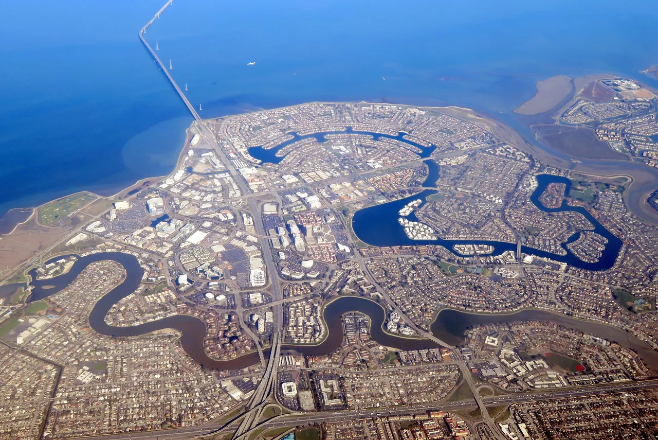 Aerial view of Foster City neighborhoods and curving lagoons beside San Francisco Bay.