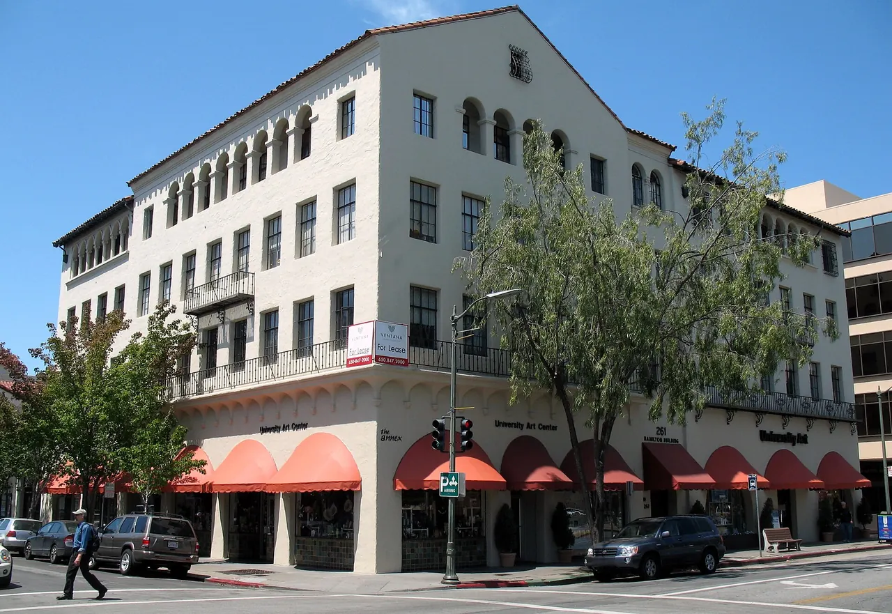 A downtown Palo Alto street corner with red awnings and Mediterranean-style architecture.