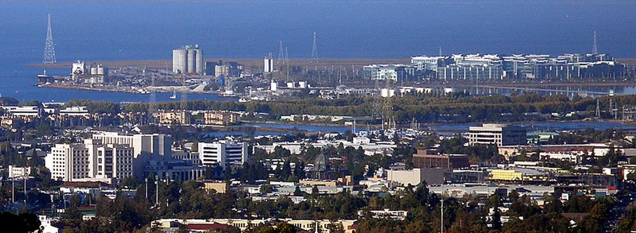 Redwood City buildings and port facilities with San Francisco Bay in the distance.