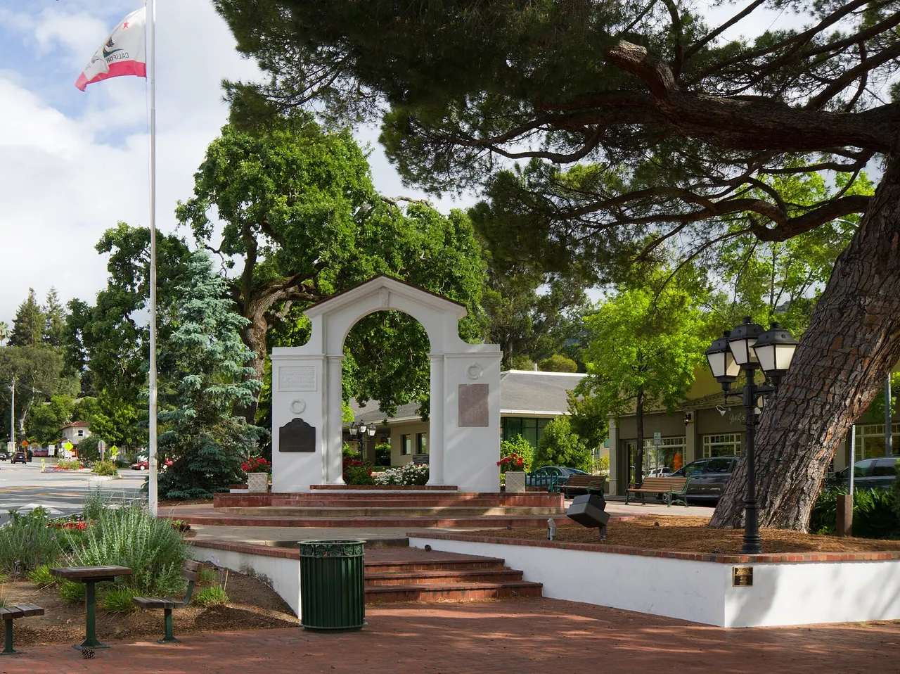 The Memorial Arch beside trees and a roadway in Saratoga.